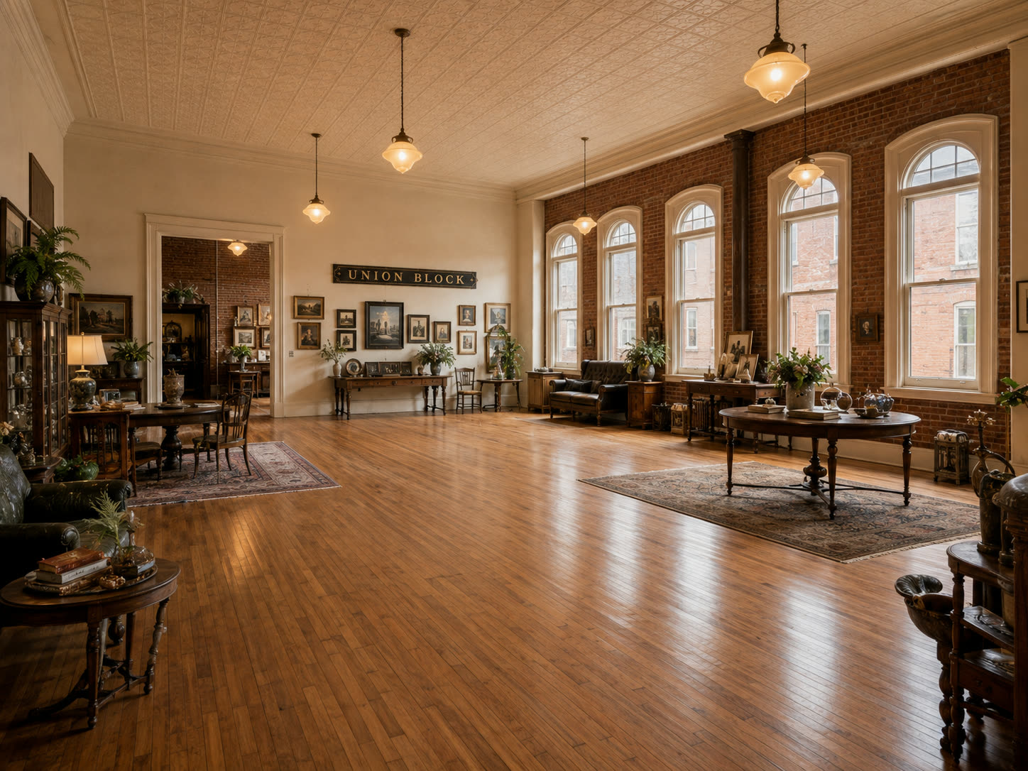 A long open work hall with a UNION BLOCK sign on the wall, desks and tables on wood floors, arched windows and brick