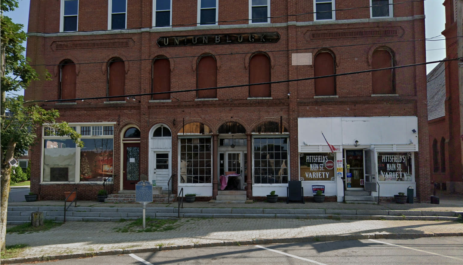The Union Block today: red brick, the old UNION BLOCK sign, boarded second-story windows above the variety store